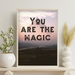 Photographic fine art poster that says, You are the Magic, over the river at sunset. Shown in context on a wall, in a living room.