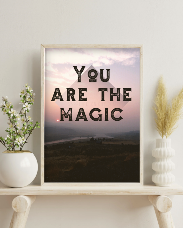 Photographic fine art poster that says, You are the Magic, over the river at sunset. Shown in context on a wall, in a living room.